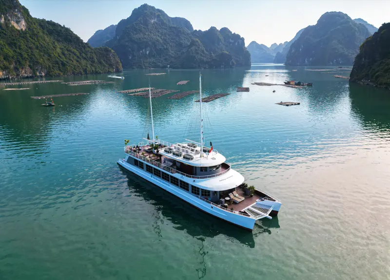 A boat crossing calm water between limestone islands