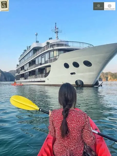 A kayaker with a yellow paddle on calm green water