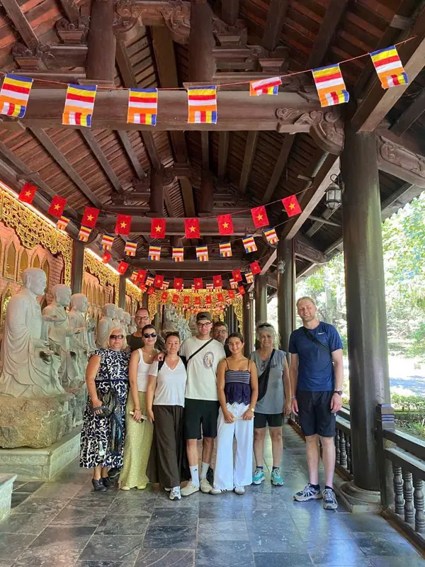 A group of guests in the carved corridor of Bai Dinh pagoda