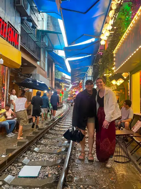 Guest and guide on Hanoi Train Street, cafes lining the rails