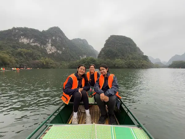 Three guests in a Trang An rowing boat